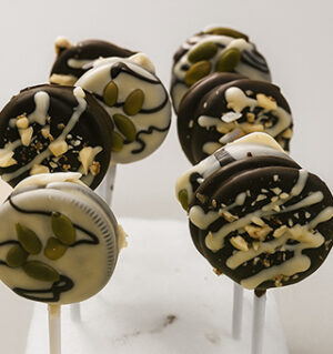 Mixed dark and white chocolate Oreo lollipops with pumpkin seeds and nut topping