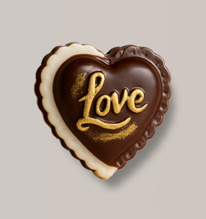 Heart-shaped dark chocolate with "Love" text and gold dust